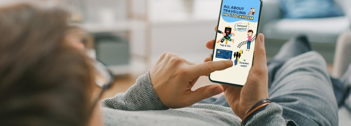 Man lies on a sofa, reads book on cell phone