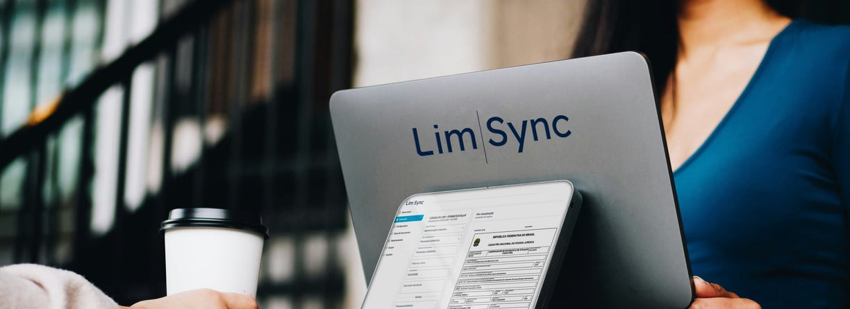 a woman sitting at a table with a laptop and a coffee cup