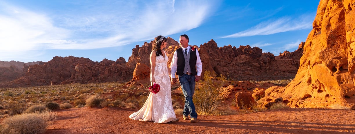 a man and woman standing in front of red rocks at Valley of Fire State Park