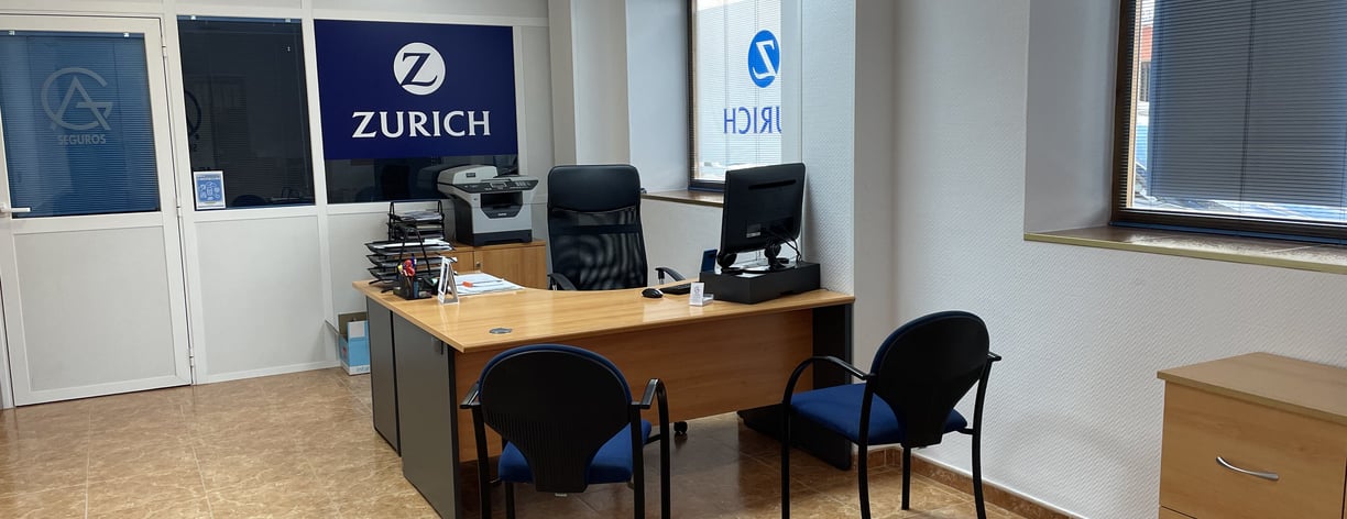 Oficina de AG Seguros - Zurich con escritorio, sillas de atención al cliente y ambiente profesional