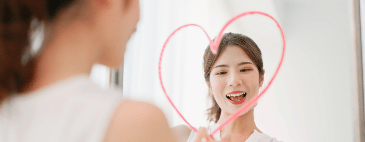 Femme qui dessine un coeur sur son miroir