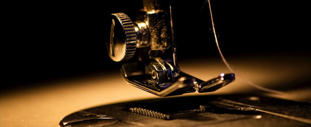 zoom sur la tete d'une machine a coudre dorée
