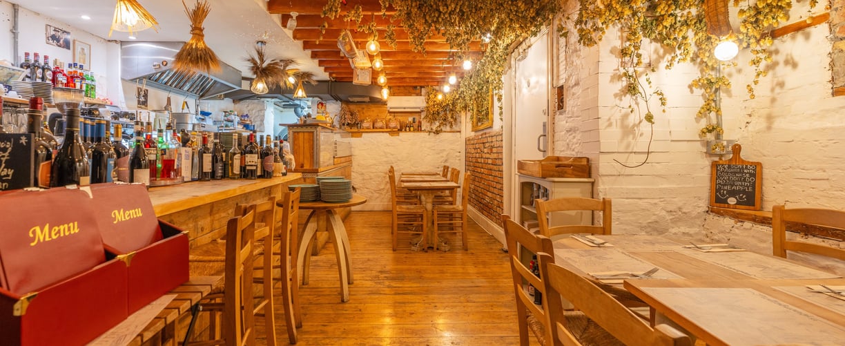 A traditional Italian restaurant with wooden tables and chairs and a bar