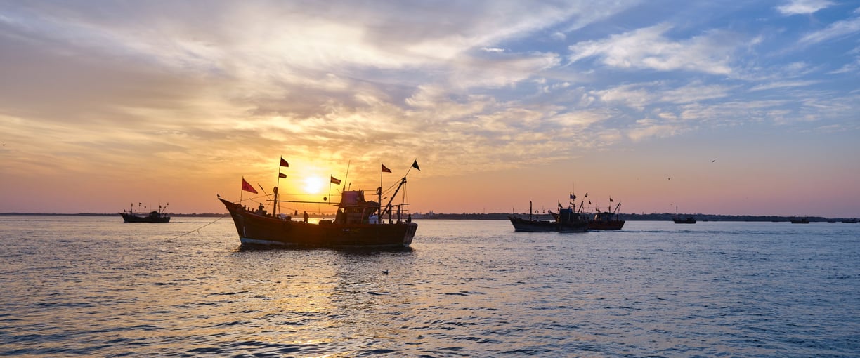 a boat in the water with a sunset in the background