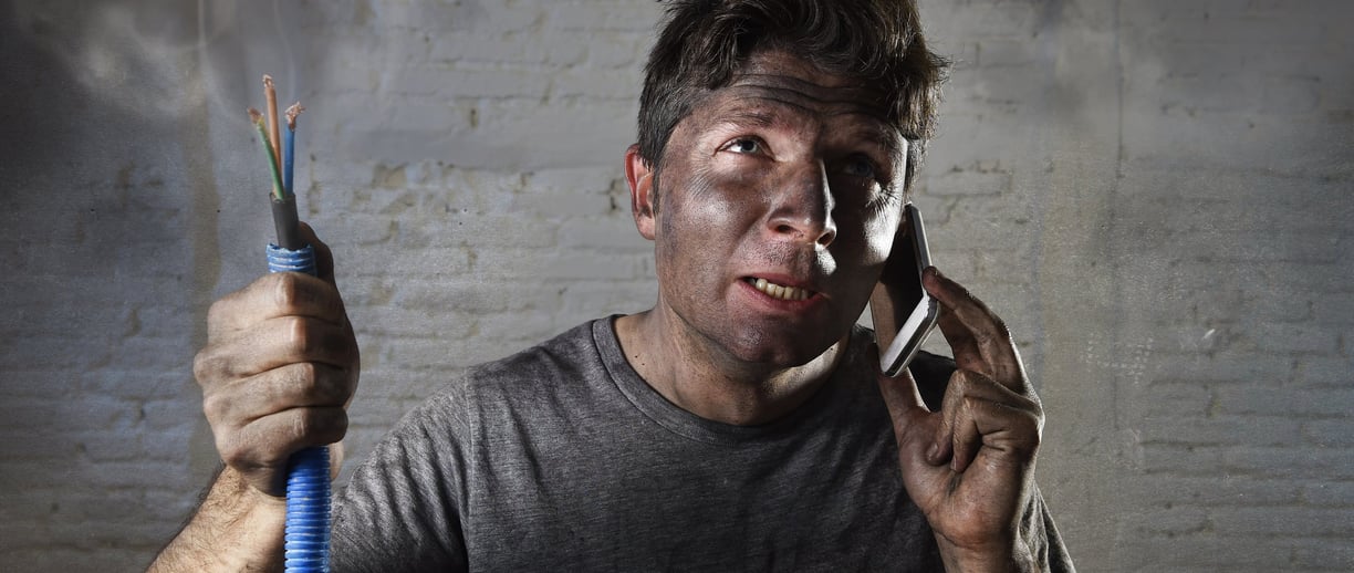 a man with aa man with a burned electrical cable and a smoky face after a fire