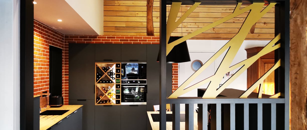 Cuisine vert foncé avec plan de travail en chêne. Claustra de séparation décor bois et couleur.