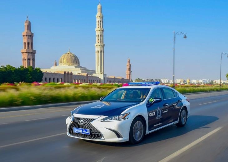 a police car driving down a street in front of a mosque