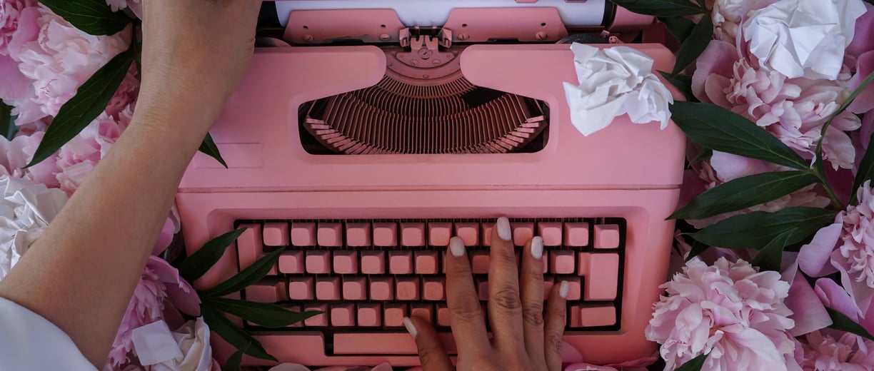 Máquina de escrever rosa em volta de flores