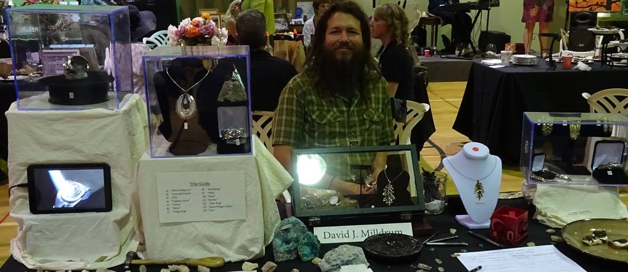 a man sitting at a table with a laptop computer