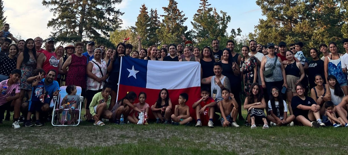 a group of people standing in front of a Chilean flag