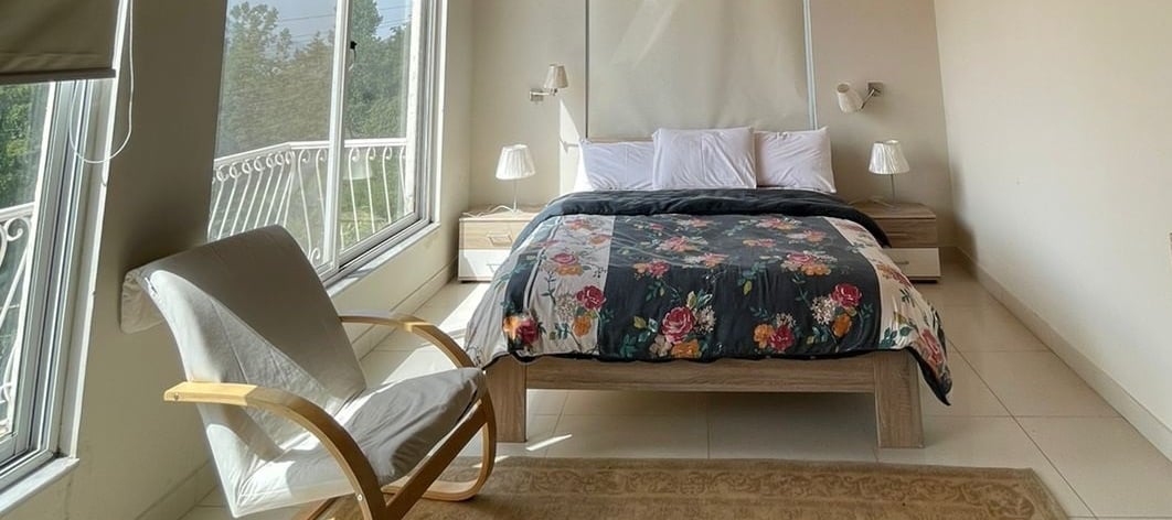 master bedroom with a ceiling fan and revolving chair with natural light coming in