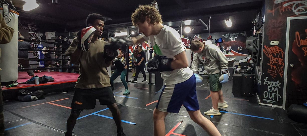 a man in a boxing ring with a punching bag