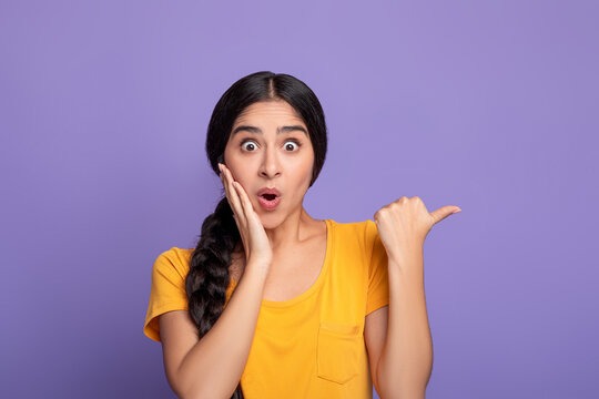 a woman with a surprised look on her face and holding her hands up to her