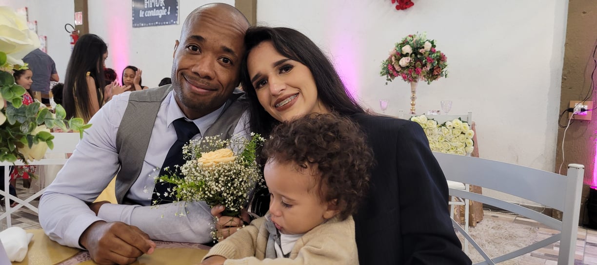 Imagem onde estou com minha família, filho, esposa, em uma festa de casamentos, sentados a mesa.