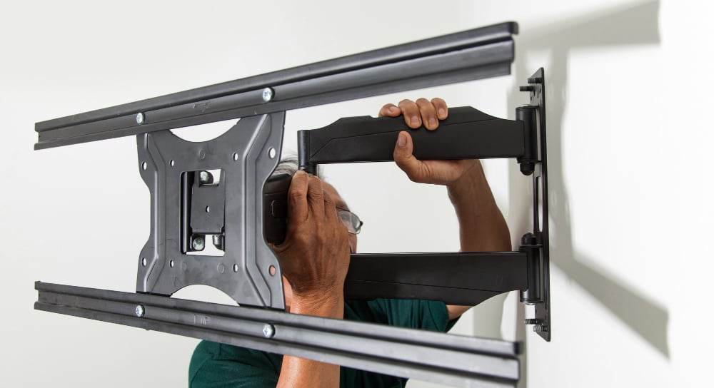 Man holding a tv mount for Morgan Hill TV installation.