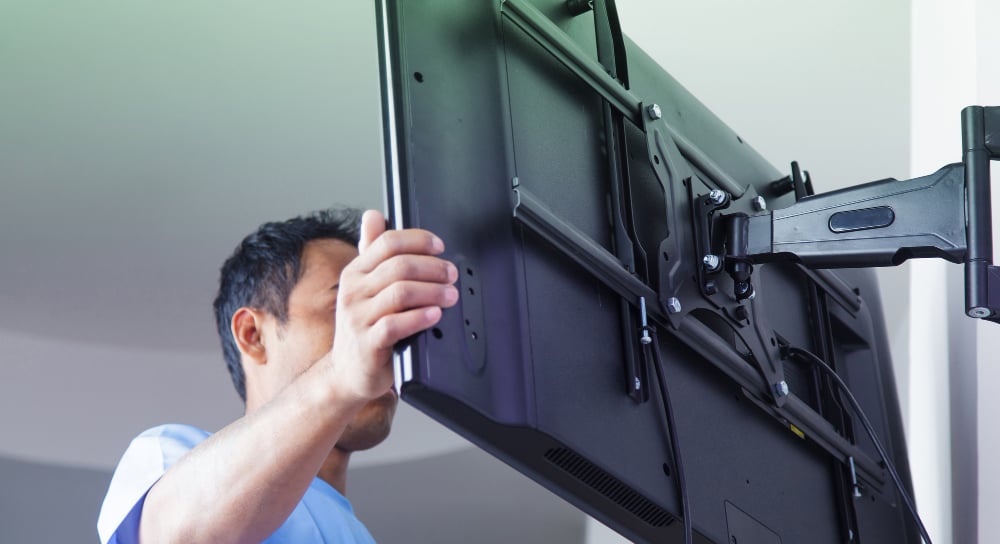 Man doing TV wall mounting for Morgan Hill TV installation.