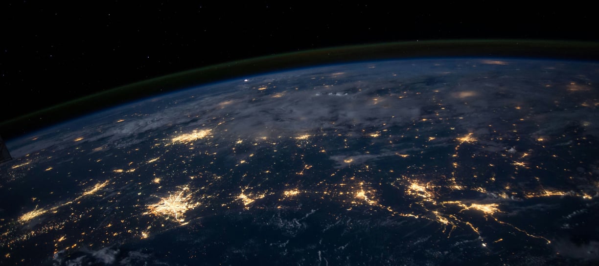 A stunning view of Earth from space, showcasing glowing city lights connected across the planet's su