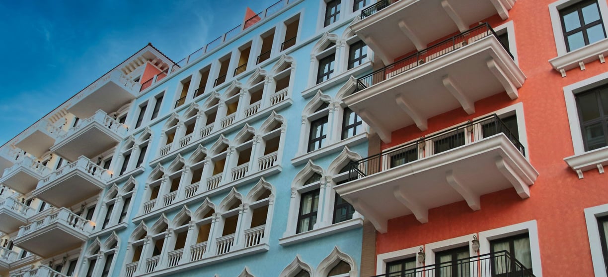 Colorful modern apartment building with blue and orange exterior walls and decorative arches.