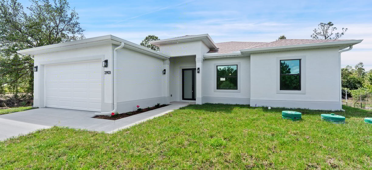 Beautifully designed front elevation of a new home for sale in Lehigh Acres, Florida. 3 beds + den,