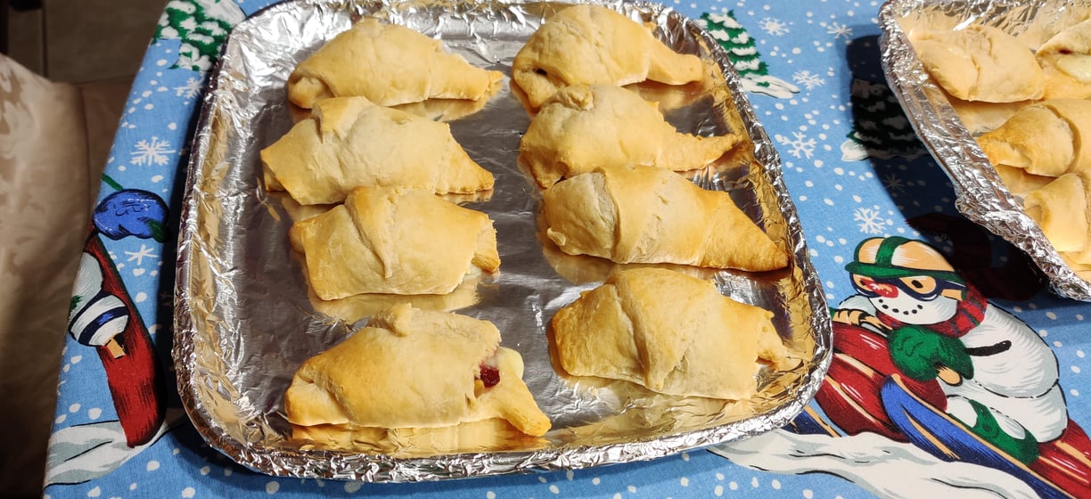 2 rows of 4 baked brie bites with cranberry orange jelly on a silver tray sitting on a winter table