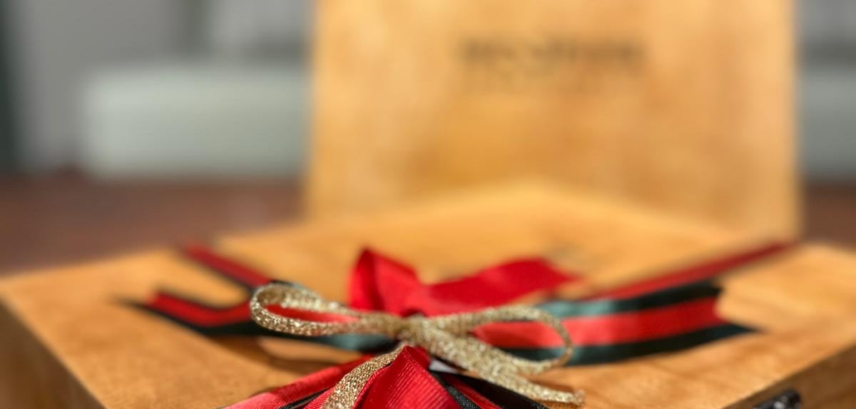 a wooden box with a red ribbon tied to it