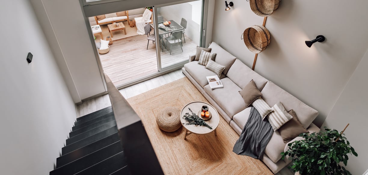 Modern living room with an iron staircase, natural wood finishes in Barcelona interior design