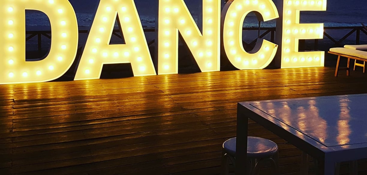 A light up sign that says "dance"