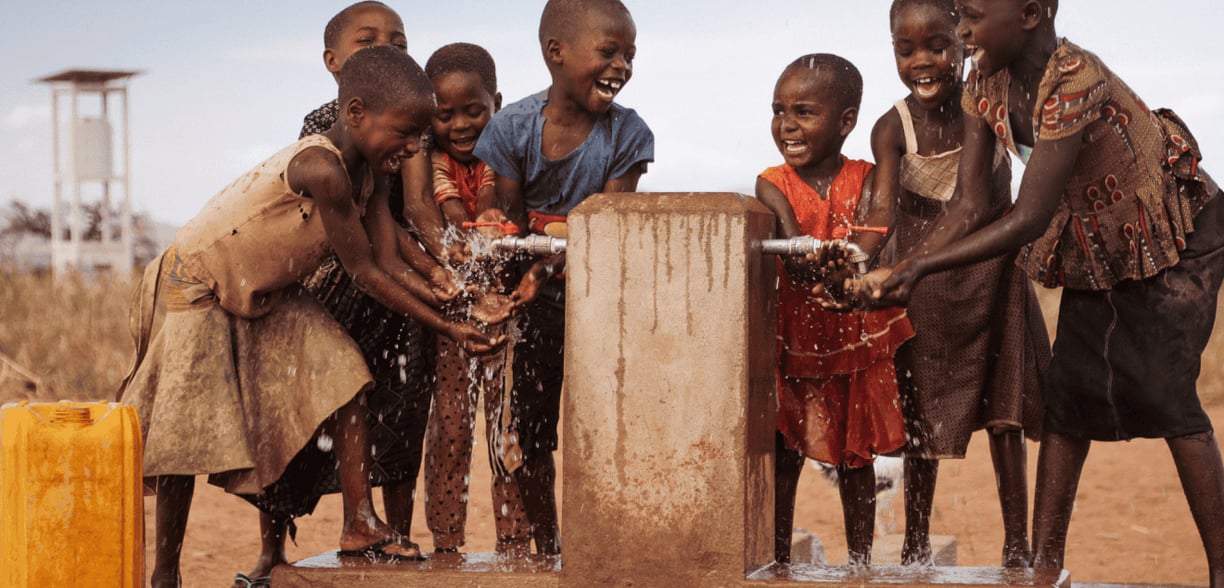 Children drinking clean water from a well in Africa