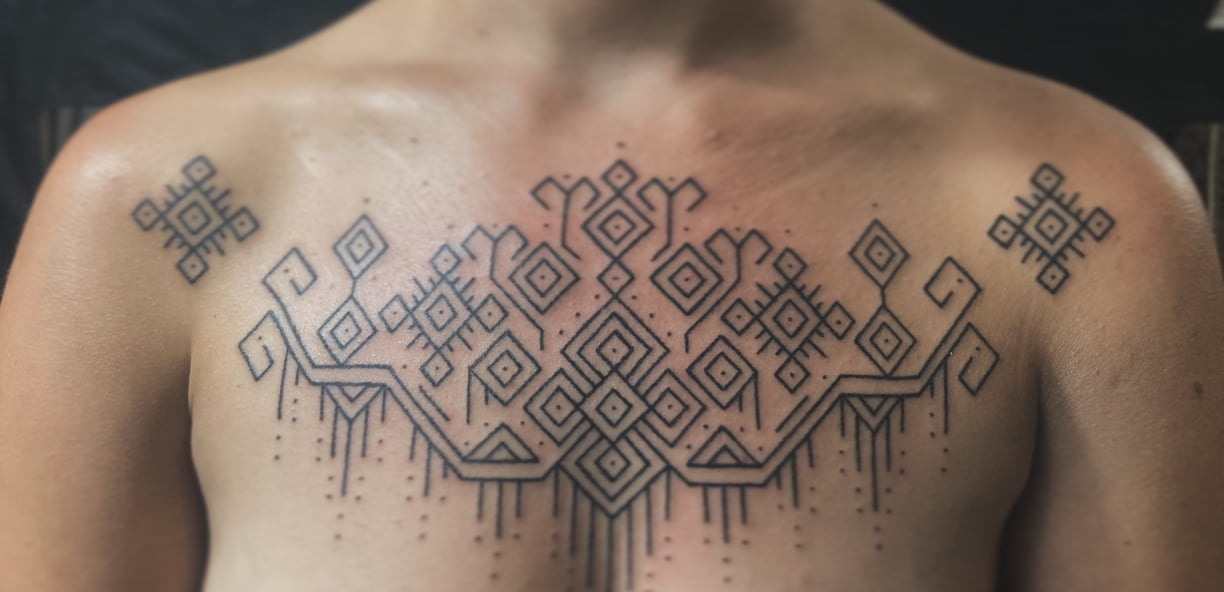 An handpoke tattoo featuring geomatric line symmetrical pattern, art tappis ornaments inspired