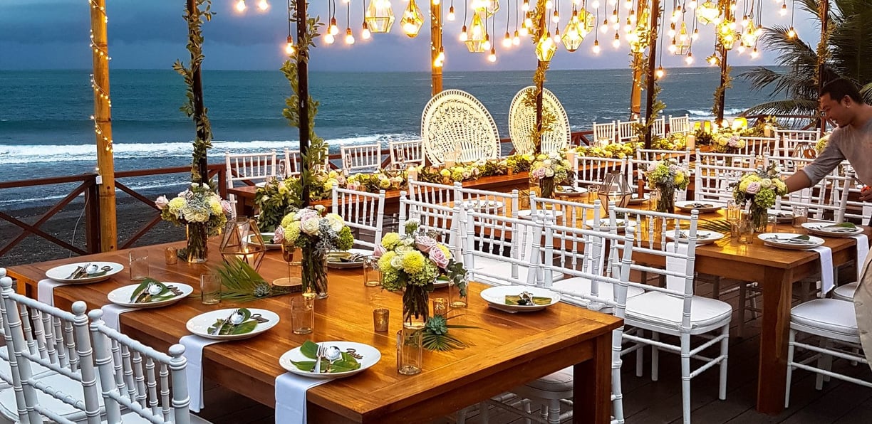 Wedding ceremony set up with hanging lights and flowers in the early evening