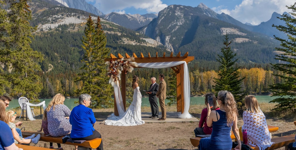 Couple having a elopement ceremony at the base of a mountain In banff