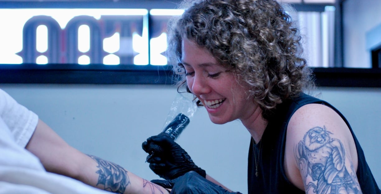 a woman tattoo artist tattooing