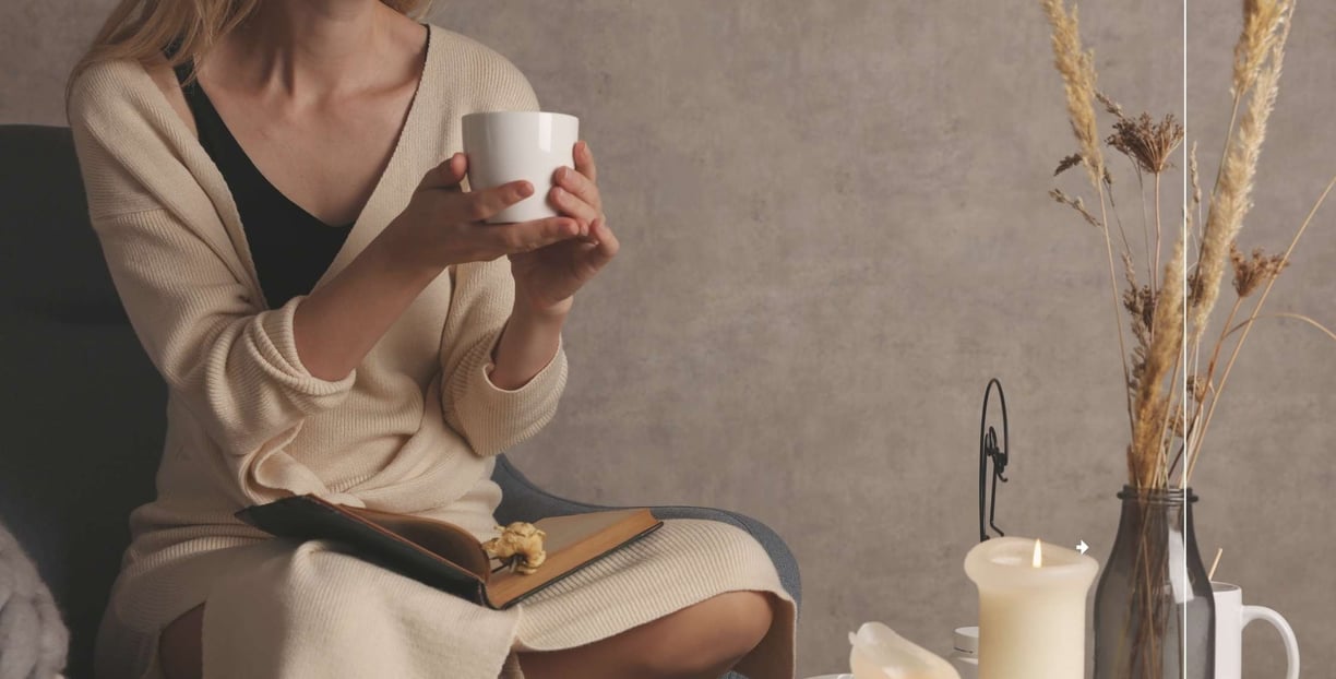 a woman sitting on a chair holding a cup of coffee