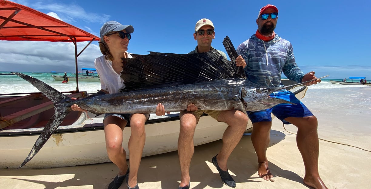 Fishing in Zanzibar for beginners - A guide helping a tourist with their first catch.