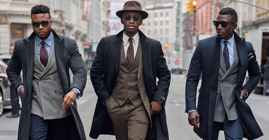 three men in suits walking down a street