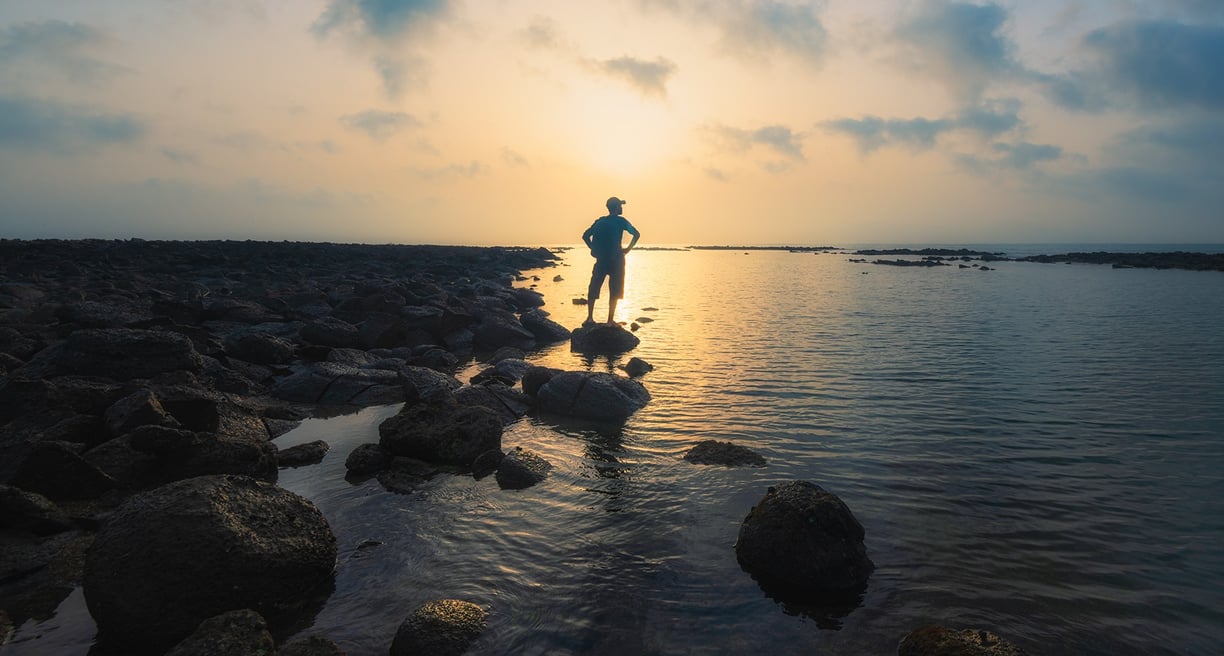 a man standing on rocks in the water