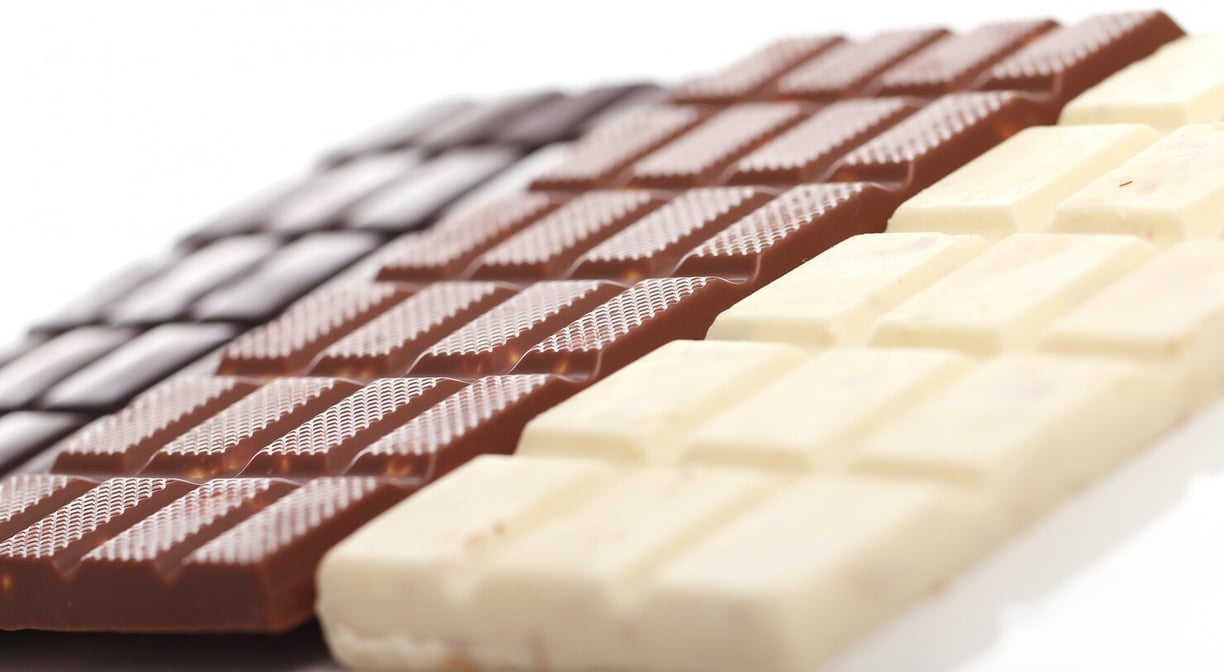 Close up of different chocolate bars. White, Milk, & dark chocolate bars on white background.