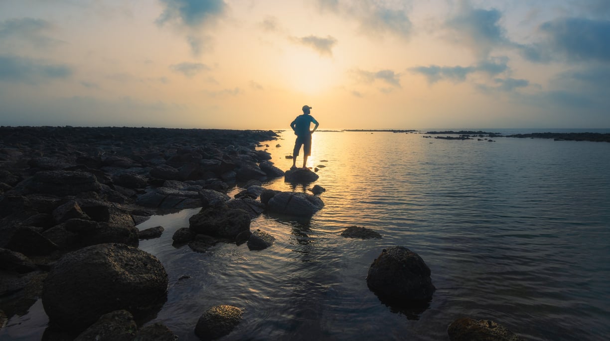 a man standing on rocks in the water