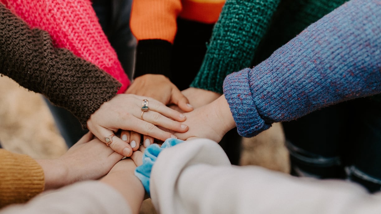 People holding hands in center. Organizational culture.