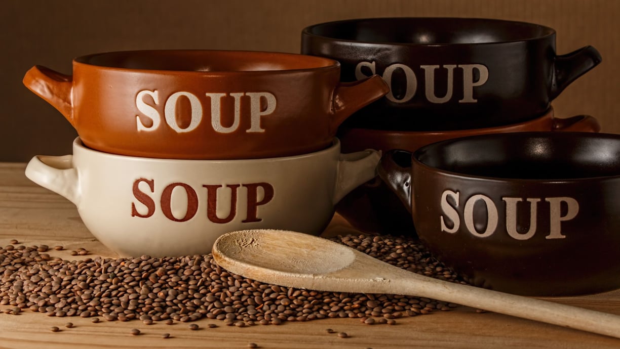 a variety of soup bowls with spoons and spoons