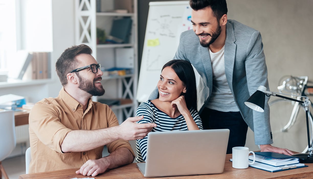 um homem e uma mulher sentados à mesa com um laptop transformando cliques em vendas