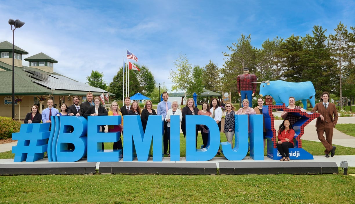 a group of people standing in front of a sign that says bemidji