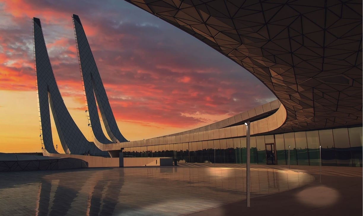 Fachada arquitectónica con sistema de lamas y diseño lumínico exterior al atardecer