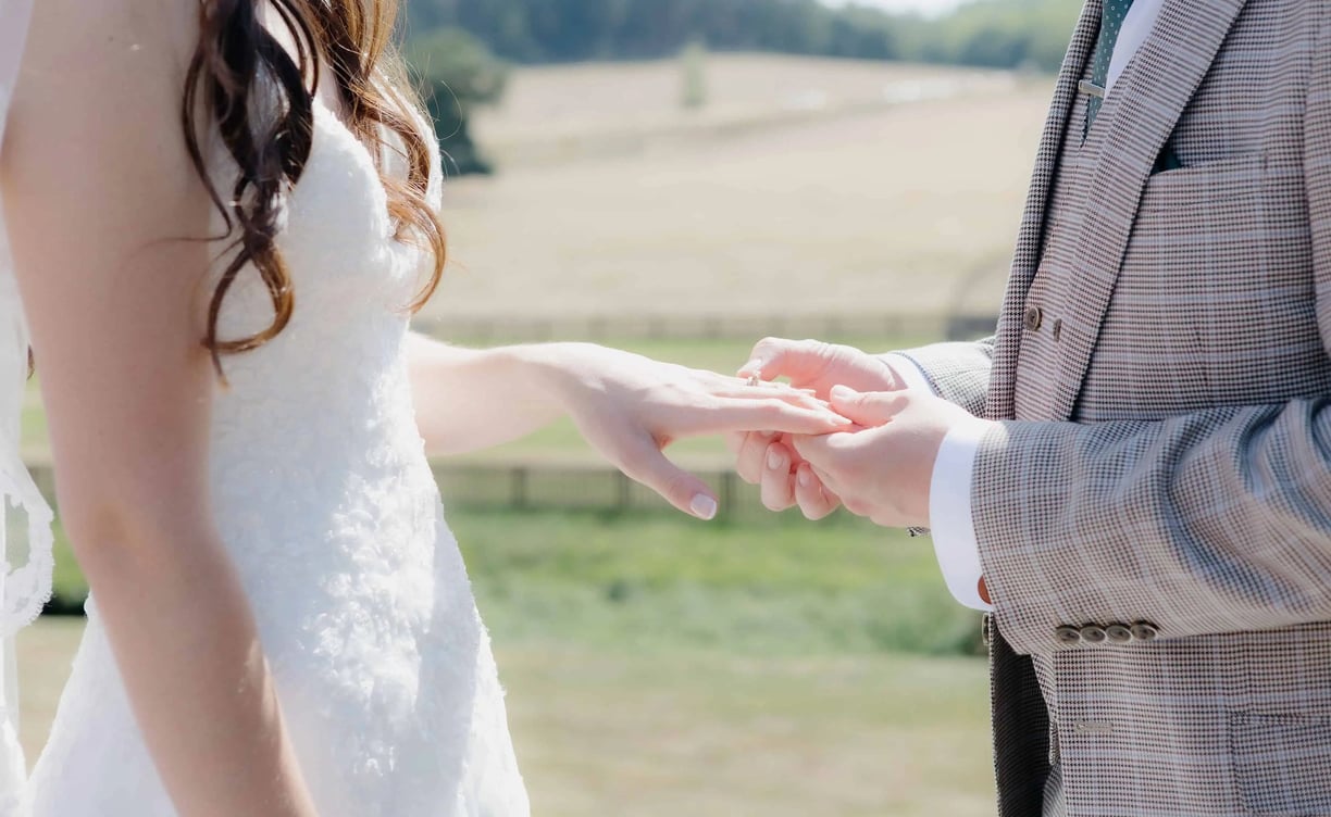 Groom placing a ring onto the finger of the bride