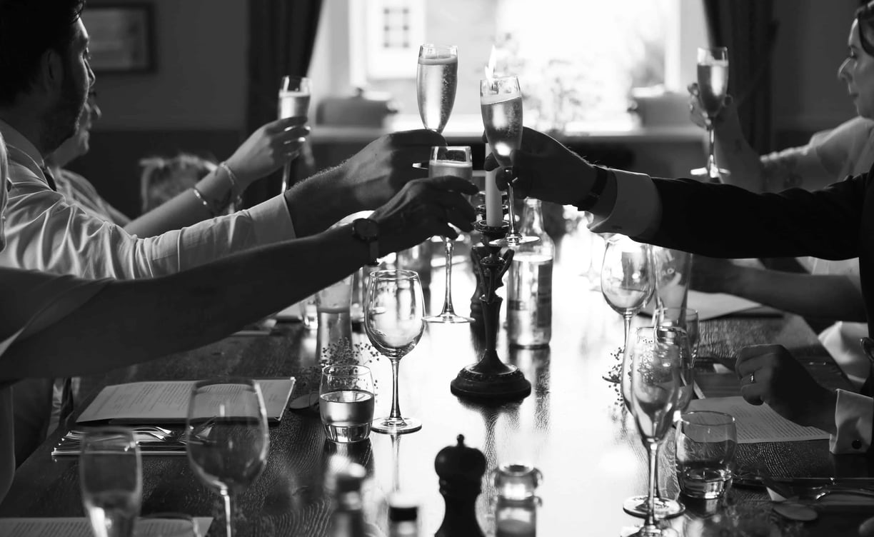 Classy black and white photo of wedding guests drinking champagne