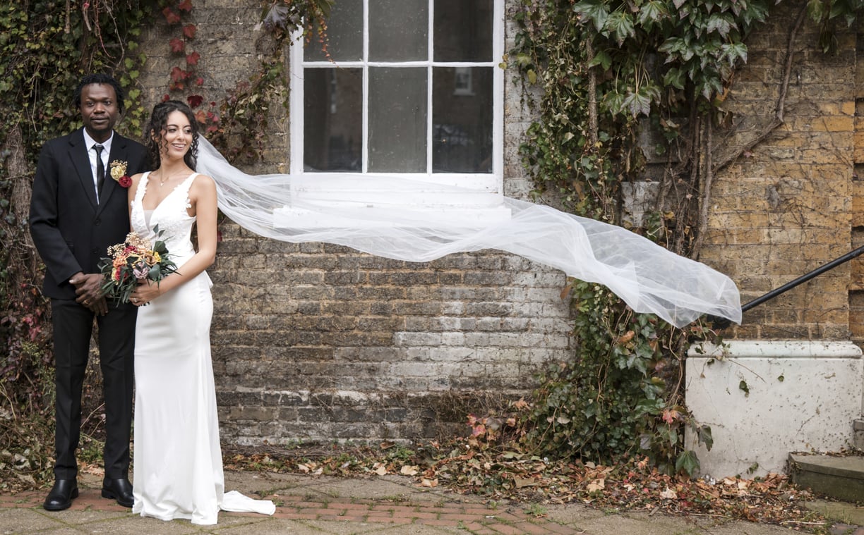 Hertfordshire Bride & Groom standing with the brides veil blowing in the wind
