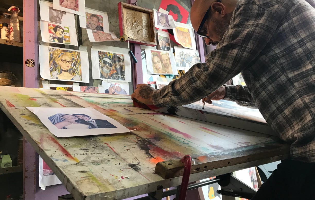 Sérgio Astral assinando uma pintura Pop-Art finalizada, dando seu toque final na obra.