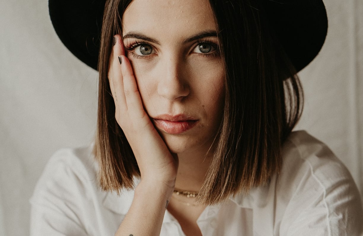 a woman in a white shirt and black hat