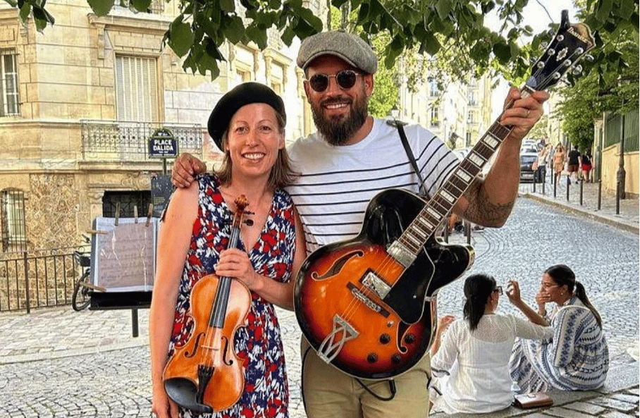 a man and woman standing in front of a guitar