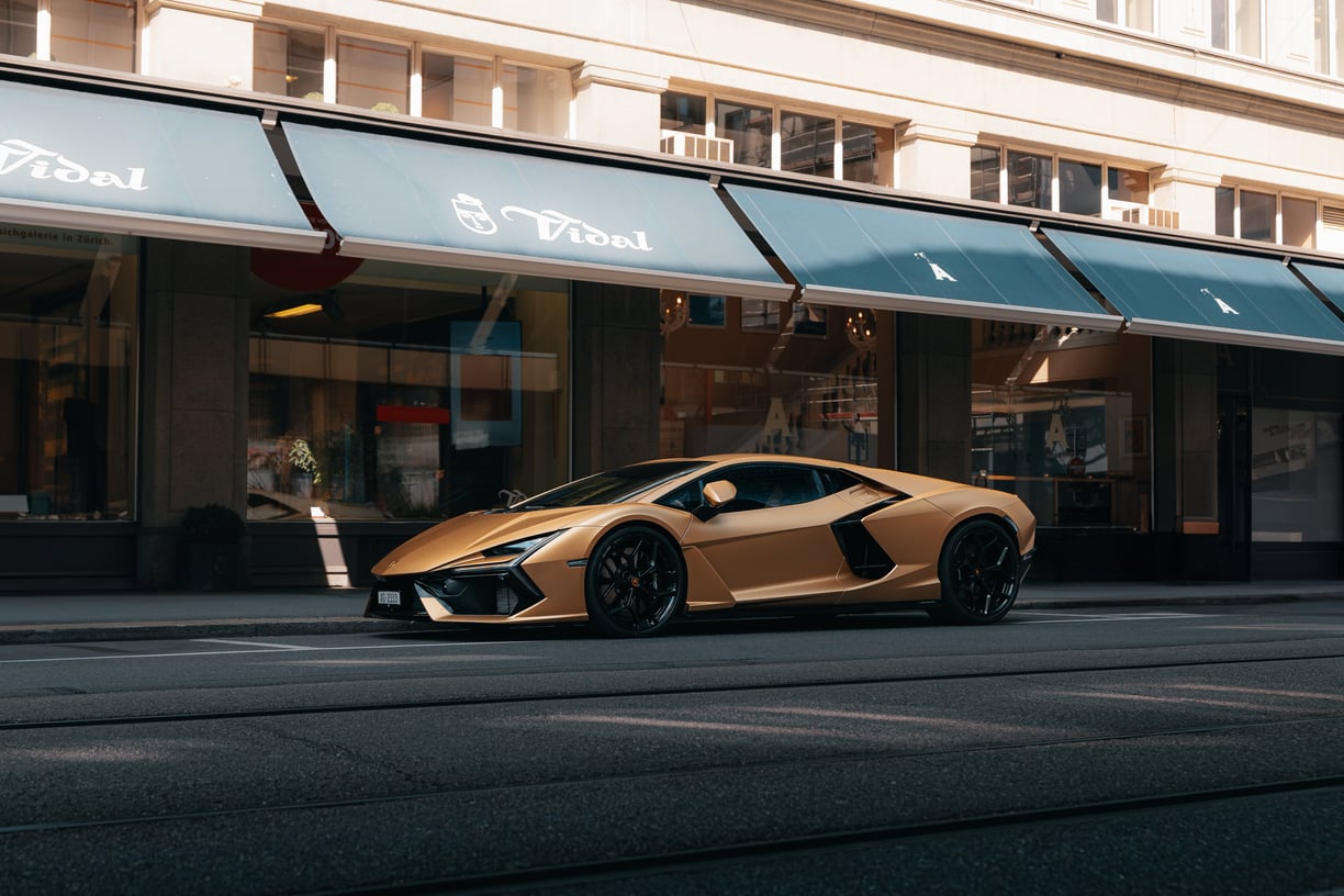 a gold colored lamborghini revuelto parked on the side of a street